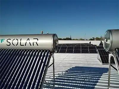Termotanques solares instalados sobre techo metálico junto a paneles fotovoltaicos