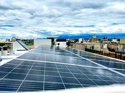 Paneles solares instalados en techo de vivienda con vista panorámica de la ciudad